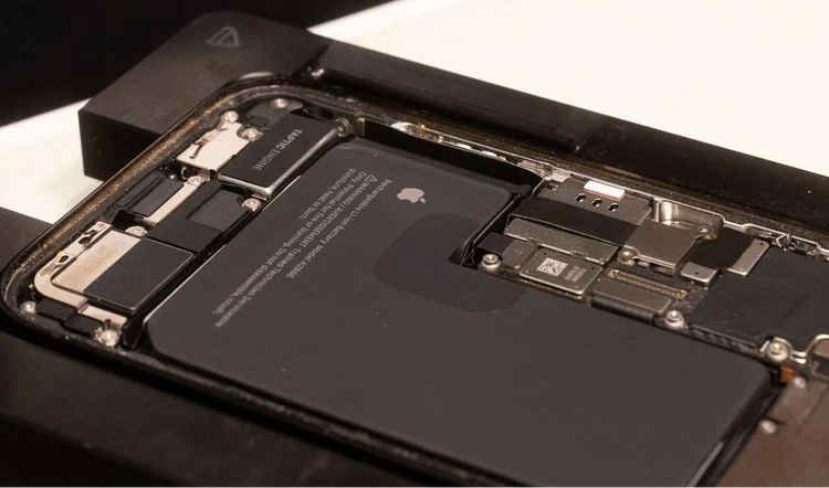 Technician inspecting an iPhone at a Jump+ service bench