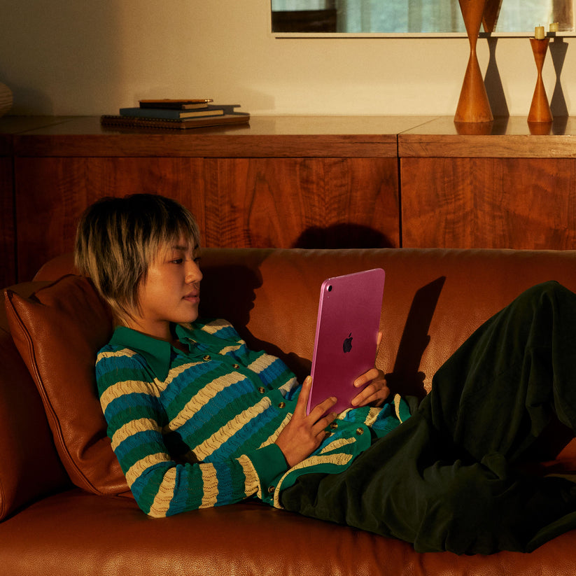 iPad A16 in Pink being used on a couch in a home setting