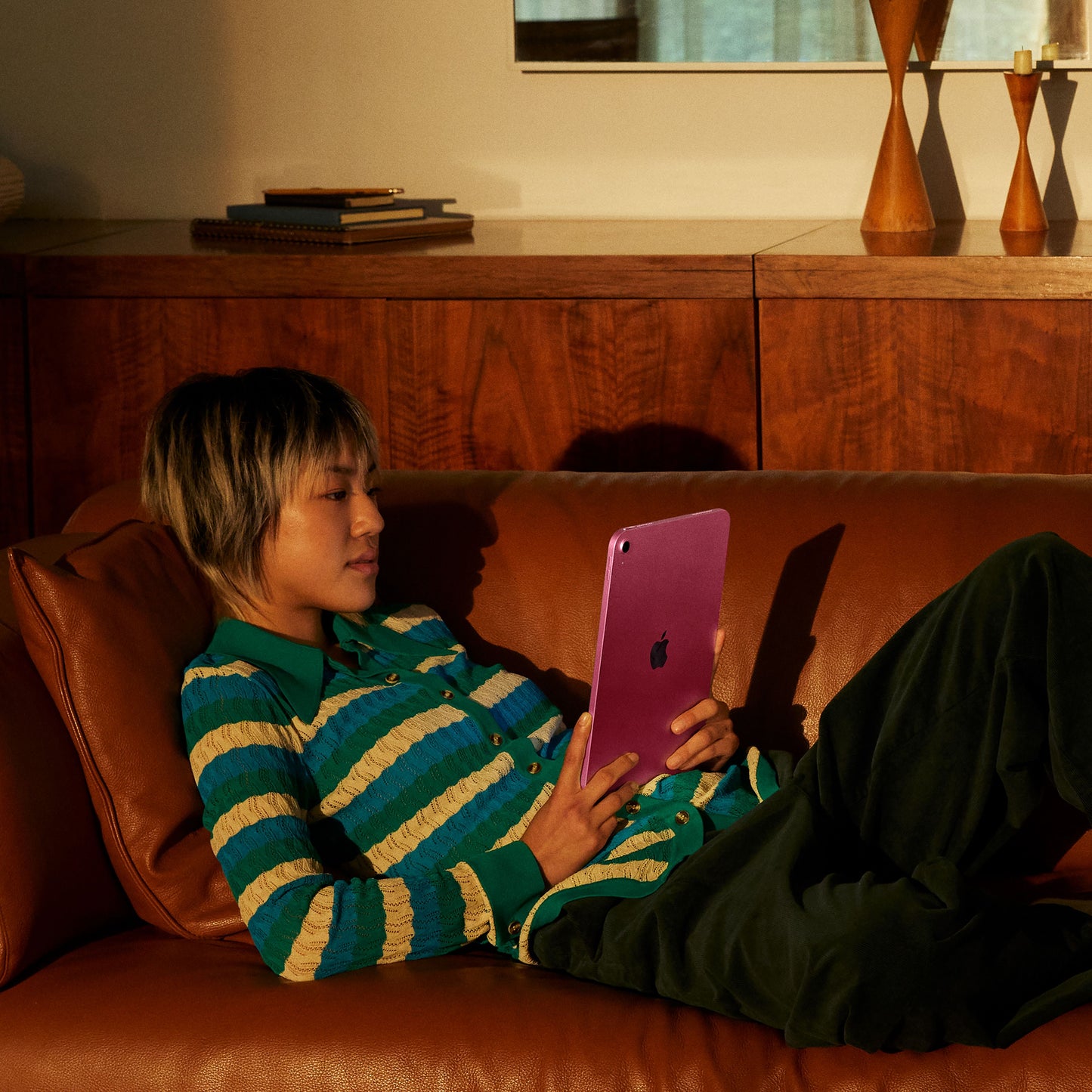 iPad A16 in Pink being used on a couch in a home setting